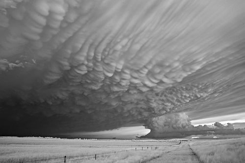 Photographie de paysage avec de larges nuages, phénomène météorologique important appelé mammatus.